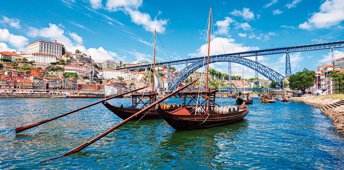 A view of rabelo boats sailing on the Douro river in Oporto, Portugal